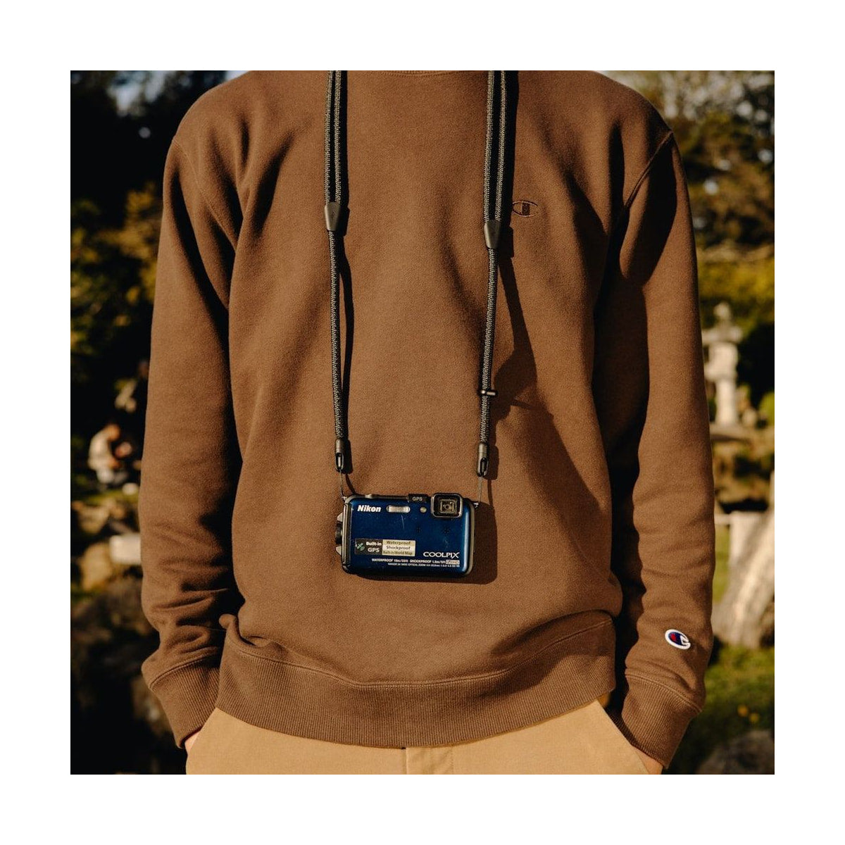 Peak Design Mobile Crossbody Strap (Black) — black strap worn with compact camera view