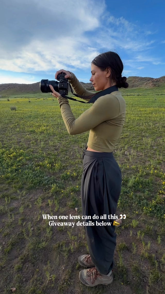 Paige Tingey photographing in a green mountain landscape during the Tamron giveaway reel.